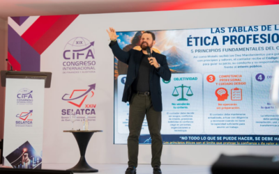 Speaker on stage gesturing with a microphone beside a large presentation about professional ethics.